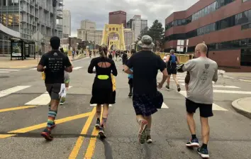  ?? Dani Marsh ?? Dani Marsh, center left, and cousin Joshua Line, center right, run the EQT Pittsburgh 10 Miler on Nov. 7 in kilts to memorializ­e their cousin, Michael Bolger.