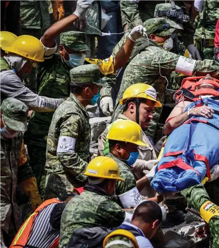  ?? — AFP ?? A survivor is pulled out of the rubble from a flattened building in Mexico City on Wednesday