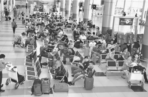  ??  ?? Passengers waiting for flights as Sibu Airport resumed operations yesterday.