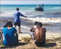  ?? AP PHOTO ?? In this photo released by the Libyan coast guard, African migrants who were found on a damaged rubber boat in the Mediterran­ean Sea and rescued by the Libyan coast guard arrive to shore, east of the capital, Tripoli, Libya.