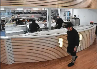  ?? PHOTOS BY DANA JENSEN/THE DAY ?? Above, the open kitchen area of Go Fish restaurant is seen Thursday at the new location in Stonington. Below, Go Fish owner Jon Kodama talks with bartender/server Amber Legare in the bar and lounge area of the restaurant.