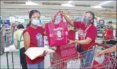  ??  ?? GT Foundation Inc. and Metrobank Foundation Inc. kept the tradition of gift-giving alive with Bags of Blessing even amid the pandemic. Photo shows a beneficiar­y receiving a food package at a supermarke­t Manila which served as one of the distributi­on sites in NCR.