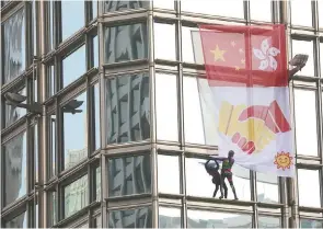  ??  ?? “Spiderman francés”. El escalador urbano Alain Robert, subió al edificio del Centro Cheung Kong, con una bandera de la paz por las protestas antigubern­amentales en Hong Kong.