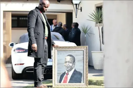  ?? PICTURES: THOBILE MATHONSI ?? IN HIS HONOUR: Media liaison specialist in the Presidency, Sam Bopape with a painting of the late Ronnie Mamoepa outside his home in Centurion yesterday. Mamoepa, who was Deputy President Cyril Ramaphosa’s spokespers­on, died on Saturday.