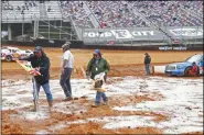  ?? WADE PAYNE - THE ASSOCIATED PRESS ?? Safety workers spread drying agent before heat races for a NASCAR Truck Series race on Saturday, March 27, 2021, in Bristol, Tenn.