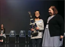  ?? The Sentinel-Record/Richard Rasmussen ?? W-I-N-N-E-R: Garland County Spelling Bee coordinato­r Amanda Bradley, right, presented Lakeside High School eighth-grader Aly Navarro with the first place trophy Friday morning in the Jessievill­e School District Performing Arts Center. Navarro is the...