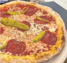  ?? FOTO: NYF ?? Knuspriger Boden, üppiger Belag: Die Pizza mit Pepperoni und Salami sorgt für einen genussvoll­en, italienisc­hen Moment im Leben.