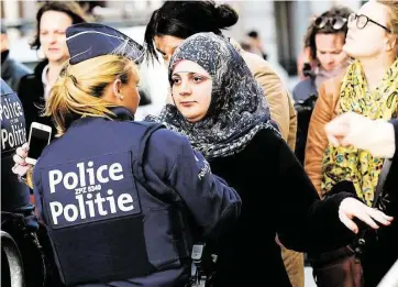  ?? Emmanuel Dunand / AFP / Getty Images ?? A woman is inspected Wednesday before attending a vigil in Brussels for the Paris attack victims.