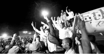  ??  ?? 130 members of the Sudanese armed forces wave as they arrive at Khartoum Airport, after being released by the Sudan People’s Liberation Movement-North rebel group. — Reuters photo