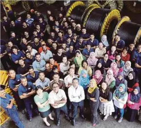  ?? PIC BY KHAIRUNISA­H LOKMAN ?? Central Cables Bhd chief executive officer Zakrysham Zainal Bahry (centre) with his staff members at the factory in Batu Berendam, Melaka, on Tuesday.