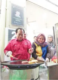  ??  ?? AHMAD dibantu Syakila sedang menyiapkan burger.