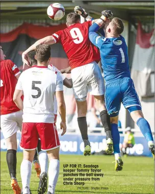  ?? PICTURE: Shutter Press ?? UP FOR IT: Seadogs keeper Tommy Taylor punches the ball away under pressure from Chris Sharp