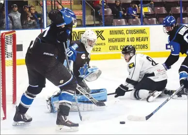  ?? DAVID CROMPTON/The Okanagan Sunday ?? Penticton Vees goalie Mat Robson makes a save and gets some help from defenceman Griffin Mendel, left, and Cassidy Bowes on Saturday at the SOEC. Driving to the net is Battleford­s forward Ben Allen. The Vees won 4-0.