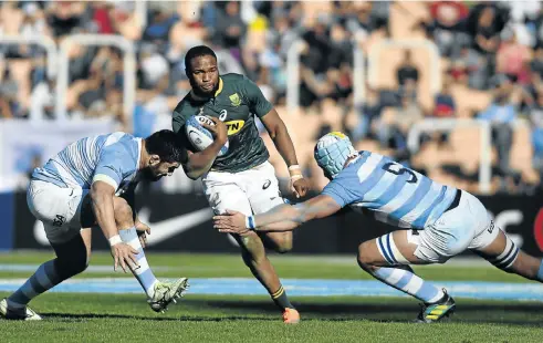  ?? Picture: Andres Larrovere / AFP ?? SA’s Aphiwe Dyantyi is tackled by Argentina’s Nahuel Tetaz Chaparro, left, and Tomas Lavanini, right, in the Rugby Championsh­ip match in Mendoza.