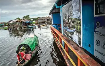  ?? SUPPLIED ?? A fisherman at Moat Klas village looks at a photograph placed on the TLC boat clinic.