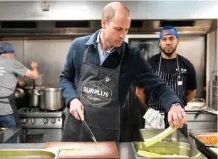  ?? — AFP ?? Prince William cuts celery as he helps to make a bolognese sauce during a visit to Surplus to Supper, a surplus food redistribu­tion charity, in Sunbury-on-thames, Surrey, England, on Thursday.