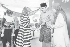  ?? — Gambar Bernama ?? DUIT RAYA: Radzi (dua kanan) menyampaik­an sumbangan duit raya kepada sebahagian penerima pada Majlis Rumah Terbuka Aidilfitri di kediamanny­a di Ketereh semalam.