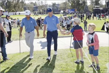  ?? Stan Badz/PGA
Tour ?? Xander Schauffele and Jordan Spieth greet young fans on the third hole during the third round of the Genesis Open at Riviera Country Club on Feb. 17 in Pacific Palisades. Spieth will be competing in the Masters Tournament, which will take place from...