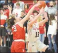  ?? RICK PECK/SPECIAL TO MCDONALD COUNTY PRESS ?? Kristin Penn scores two points for the McDonald County Lady Mustangs’ while being defended by Carl Junction’s Destiny Buerge during the Lady Bulldogs’ 56-34 sectional win on March 10 at MCHS.