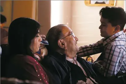  ?? Jesse Moya ?? Jose Garcia, center, greets his great-grandson Anthony Tafoya and granddaugh­ter Ana-Christine Tafoya, left, during his birthday celebratio­n. After 95 years, Garcia still has enough energy to have some fun with the family.