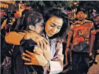  ?? LILLIAN SUWANRUMPH­A AFP VIA GETTY IMAGES ?? People hug after being rescued by Thai commandos from Terminal 21 shopping mall, where the mass shooting took place.