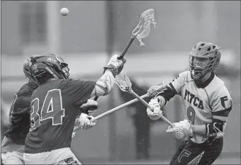  ?? DANA JENSEN/THE DAY ?? Fitch’s James Deichler (9) passes over Waterford´s Tom Quiles (34) and Cody Brown (21) during Thursday’s boys’ lacrosse game at Groton Middle School. Deicher scored four goals in a 16-6 win.