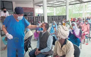  ?? BIKRAM RAI ?? Dr. Sanduk Ruit checks a patient’s eye at the Lumbini eye camp. His assembly-line surgery made it possible for nearly 400 patients to get cataract surgery in just three days.