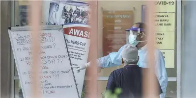  ?? – ADIB RAWI YAHYA/THESUN ?? HEALTH CHECK ... Health screening and testing for Covid-19 are being conducted at the Sungai Buloh health clinic. As the movement control order enters its seventh day, efforts continue in the search for about 3,000 people who attended a religious gathering that led to a significan­t spike in cases.