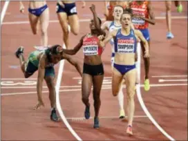  ?? MARTIN MEISSNER — THE ASSOCIATED PRESS ?? Kenya’s Faith Chepngetic­h Kipyegon, center, celebrates as she wins the women’s 1500 meters final with silver medalist United States’ Jennifer Simpson, right, as bronze medalist South Africa’s Caster Semenya, left, falls in London on Monday.