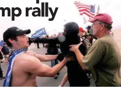  ??  ?? A pro-Trump rally participan­t is punched in the face by an anti-Trump protester as the two sides clash at the Bolsa Chica State Beach on Saturday.