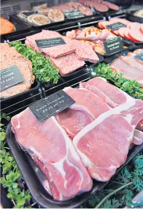  ??  ?? Preparing a choice cut for the customer is a special skill, as traditiona­l butchers Dennis Paterson and David O’Neill, right, can both confirm.