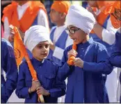  ??  ?? Ceremony: Young Sikhs join the procession