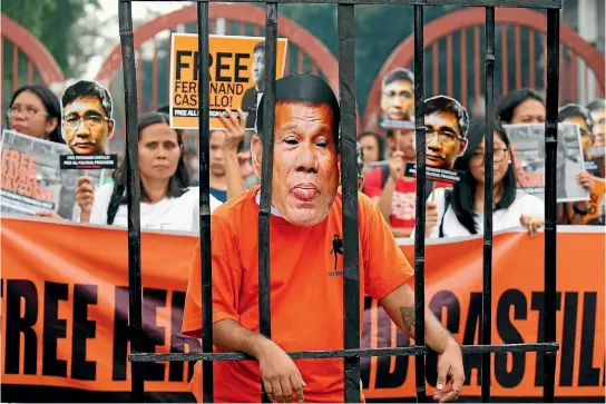  ?? PHOTO: AP ?? Protesters display cutouts of detained communist peace talks consultant Ferdinand Castillo behind a mockup of Philippine­s President Rodrigo Duterte in jail, during a rally calling for the release of Castillo and another re-arrested communist leader,...