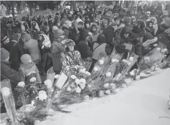  ?? CP FILE PHOTO ?? People place flowers after a vigil at the Centre culturel islamique de Quebec on Jan. 29 to mark the first anniversar­y of the fatal mosque shooting in Quebec City.