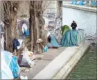  ?? JOEL SAGET/AFP ?? A man stands near tents at a makeshift migrant camp, mainly made up of Afghans, along the Saint-Martin canal in Paris on Wednesday.