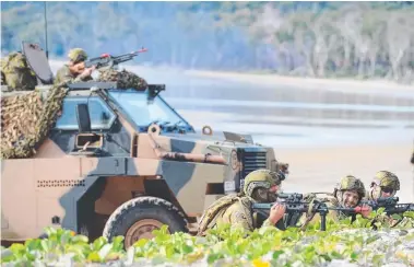  ?? An Army soldiers of the Amphibious Beach Team take cover from enemy fire as they prepare to support ts coming ashore at Freshwater Beach in Shoalwater Bay Training Area, during Exercise Hamel 2018. ??