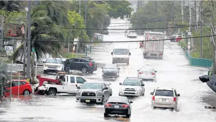  ?? SUSAN STOCKER/SOUTH FLORIDA SUN SENTINEL 2017 ?? Traffic maneuvers through a flooded A1A just south of Dania Beach Boulevard because of rising waters from a king tide. Florida has begun assessing the threat that sea rise poses to a sprawling transporta­tion network essential to the state’s economy.