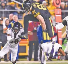  ?? THE ASSOCIATED PRESS ?? Pittsburgh Steelers tight end Jesse James (81) leaps over Baltimore Ravens cornerback Chris Lewis-Harris before being tackled by cornerback Tavon Young (36) during the second half in Pittsburgh on Sunday.