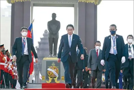  ?? HENG CHIVOAN ?? Japanese Prime Minister Fumio Kishida (centre) walks past an honour guard after laying a wreath at a statue of the late King Father Norodom Sihanouk in Phnom Penh on Sunday.