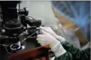  ?? MARK SCHIEFELBE­IN — THE ASSOCIATED PRESS ?? Zhou Xiaoqin installs a fine glass pipette into a sperm injection microscope in preparatio­n for injecting embryos with Cas9 protein and PCSK9 sgRNA at a lab in Shenzhen in southern China’s Guandong province. China’s government on Thursday ordered a halt to work by a medical team that claimed to have helped make the world’s first gene-edited babies.