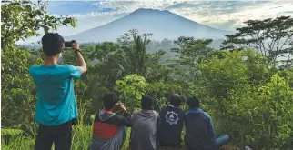  ?? AFP ?? PEOPLE look at Mount Agung in Karangasem on the Indonesian resort island of Bali on Sept. 24.