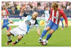  ??  ?? UNDER CONTROL: Atletico Madrid's French forward Antoine Griezmann, right, vies with Deportivo La Coruna's defender Laure during the Spanish league football match at the Vicente Calderon stadium in Madrid on Sunday. (AFP)