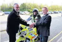  ??  ?? ●● Jeff Cottam (right) hands a cheque for £7,000 to North West Blood Bikes chairman Paul Brooks and volunteer blood biker Neil Naisbitt