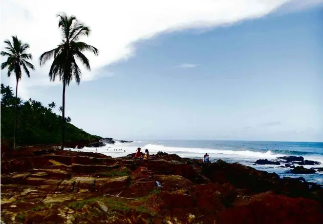  ?? Fotos Roberto de Oliveira/Folhapress ?? Visitantes apreciam o fim de tarde na Resende, uma das praias urbanas de Itacaré, com mata, coqueiros, ondas e piscinas naturais na maré baixa, no sul da Bahia