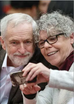  ??  ?? „ Labour leader Jeremy Corbyn poses for a photograph during a Christmas lunch for homeless people at Nelson Hall in Edinburgh yesterday.