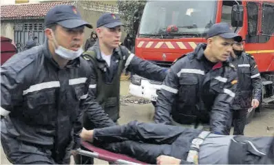  ?? AFP ?? Els serveis d’emergència transporte­n un dels ferits en el taller tèxtil clandestí.