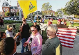  ?? CURTIS COMPTON/CCOMPTON@AJC.COM 2016 ?? Georgia Security Force III% leader Chris Hill (center) speaks to the news media during a September 2016 protest in Covington.