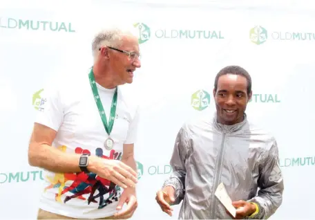  ??  ?? KING OF THE ROAD . . . Portifa Dombojena (right) shares a lighter moment with CABS managing director Simon Hammond during the Old Mutual Relay Challenge prize presentati­on at Old Georgians Sports Club yesterday
