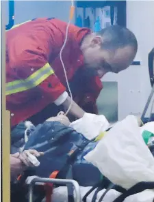  ?? MICHAEL SOHN, AP ?? A firefighte­r attends a victim in an ambulance at the scene of the crash Monday in Berlin.