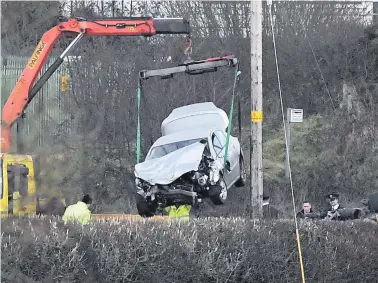  ??  ?? A car being removed from the crash scene near Omagh in which Maurice McCloughan (top) and Killian Doherty were killed